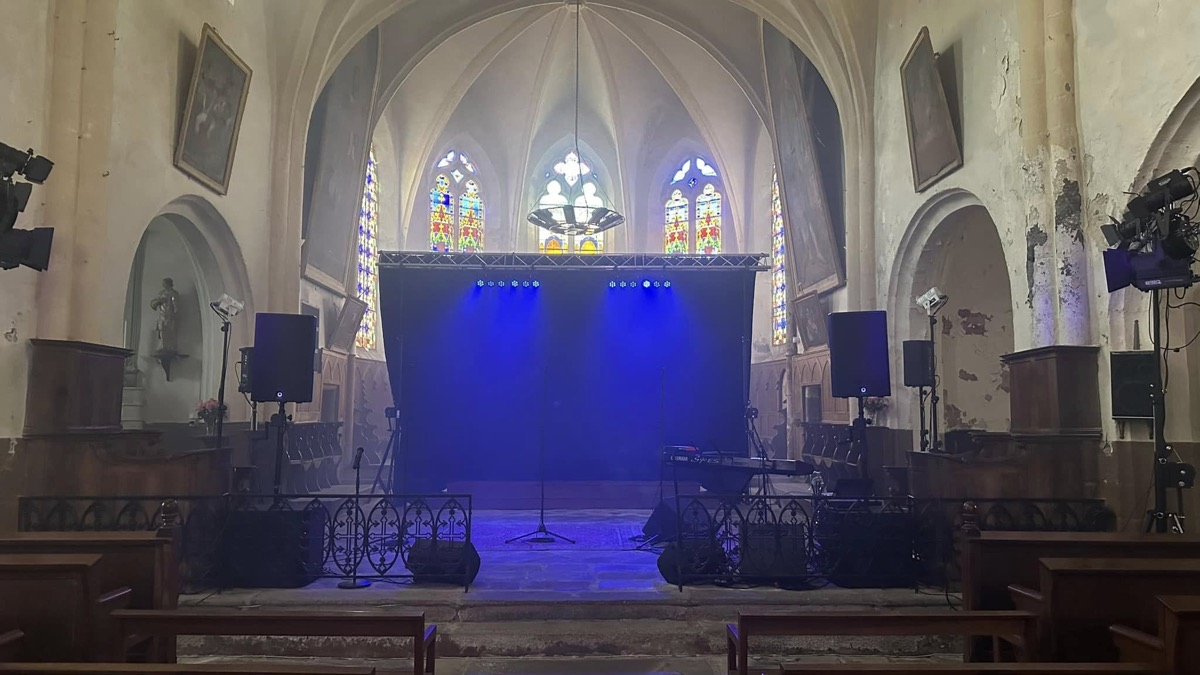 Installation de sonorisation et éclairage bleu dans l’église de Châteldon avant le concert.